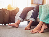 Primer plano de pies descalzos de marido y mujer en el piso de la habitación del hotel.