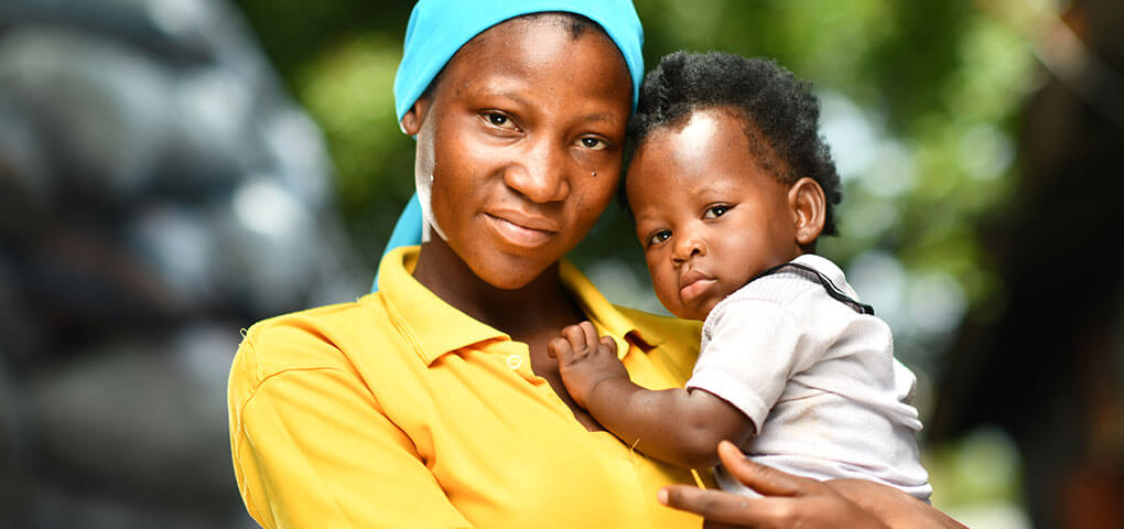 A mom holding her child closely in her arms.